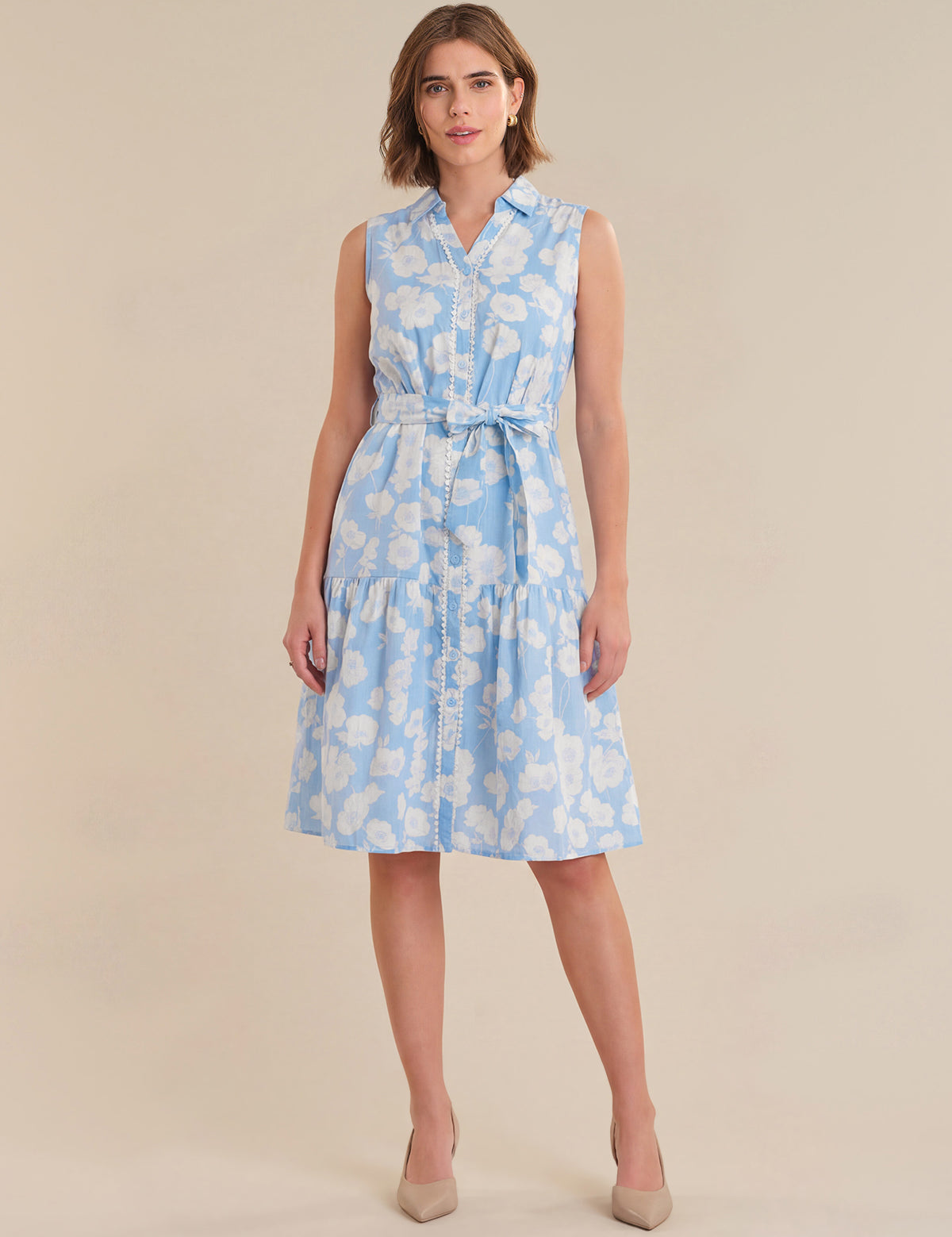Woman wearing a light blue floral dress on a beige background