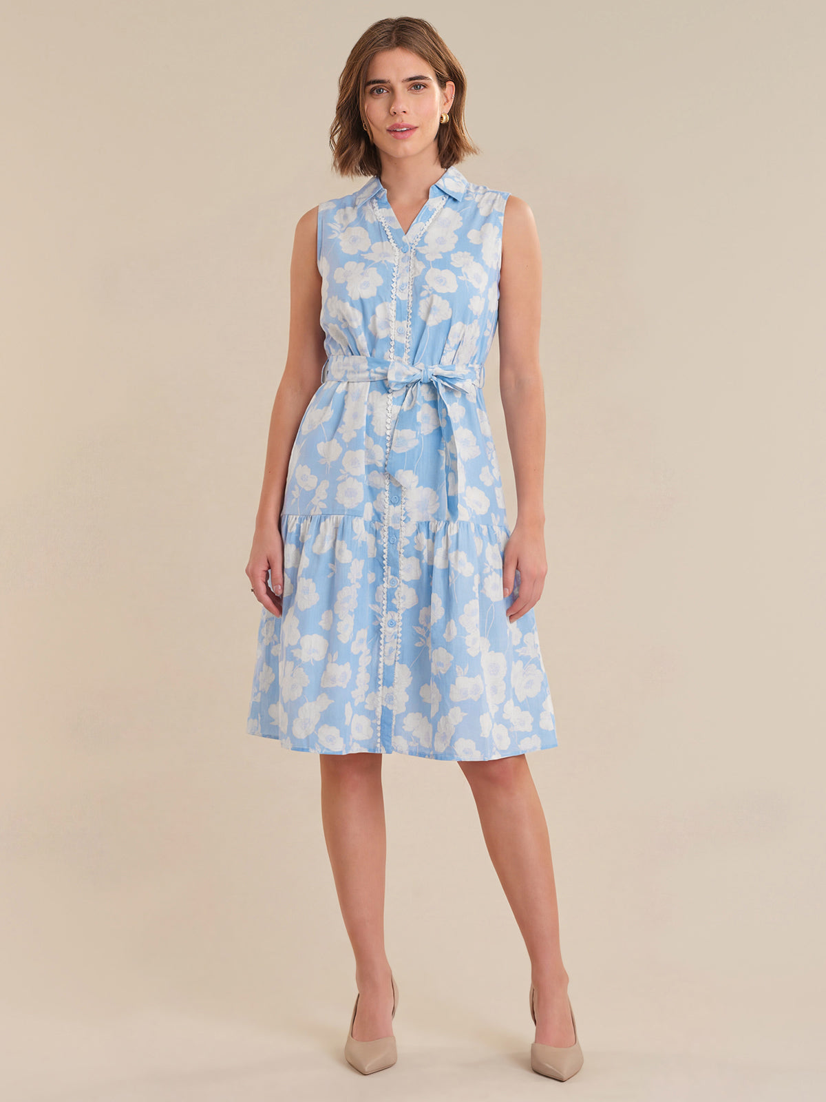 Woman wearing a light blue floral dress on a beige background