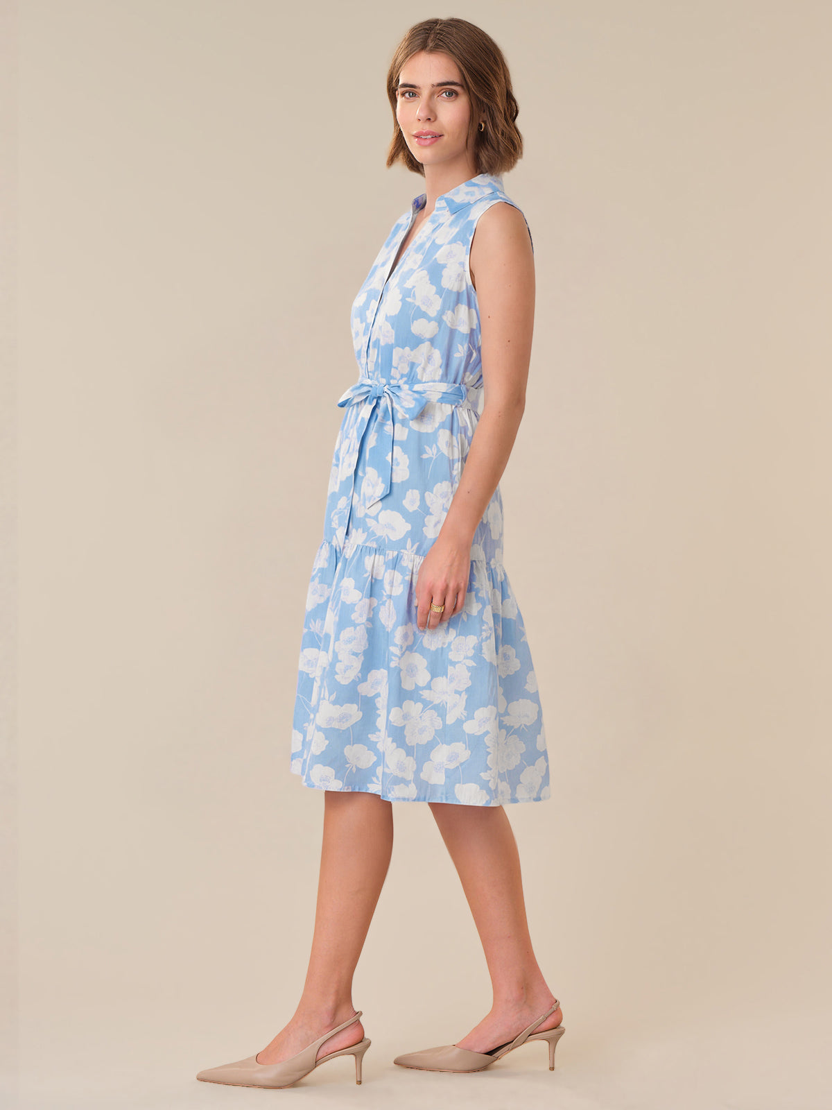 Woman wearing a blue floral dress on a beige background