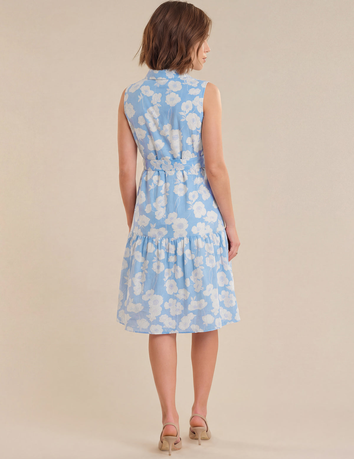 Woman wearing a light blue floral dress on a beige background