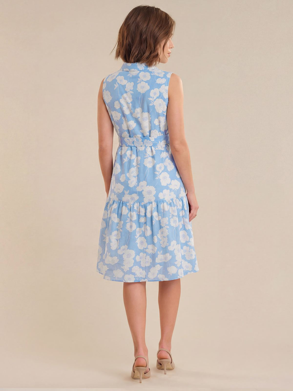 Woman wearing a light blue floral dress on a beige background