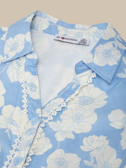 Blue floral shirt with white flowers on a light background