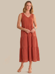 Woman wearing a rust-colored dress against a plain background