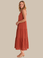 Woman wearing a rust-colored dress against a beige background