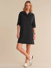 Woman wearing a black dress with a collar on a beige background