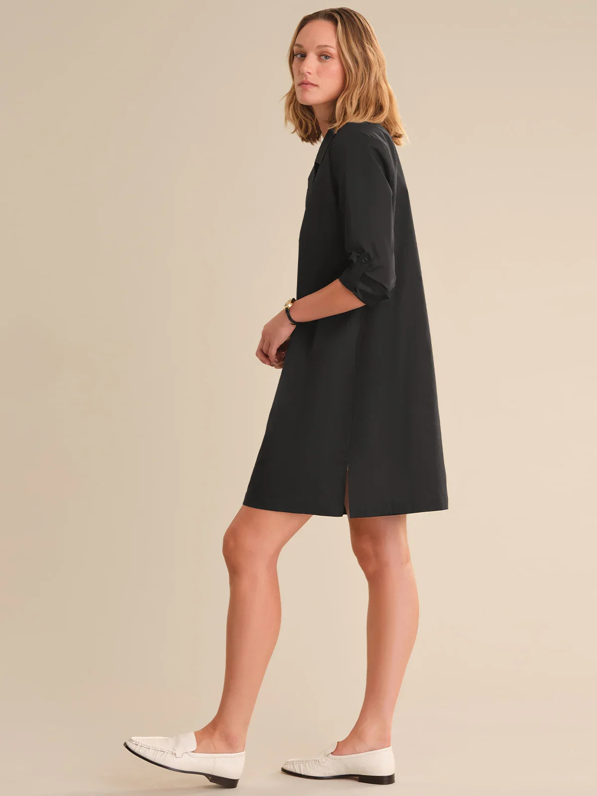 Woman wearing a black dress on a beige background