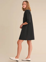Woman wearing a black dress on a beige background