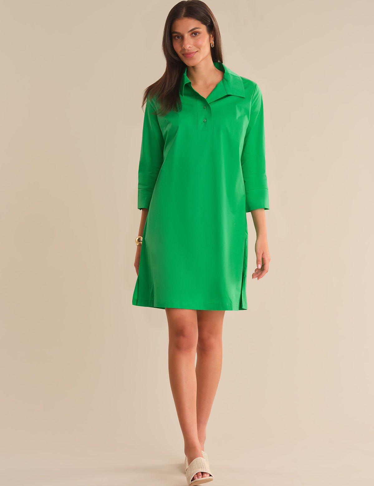 Woman wearing a green dress against a beige background