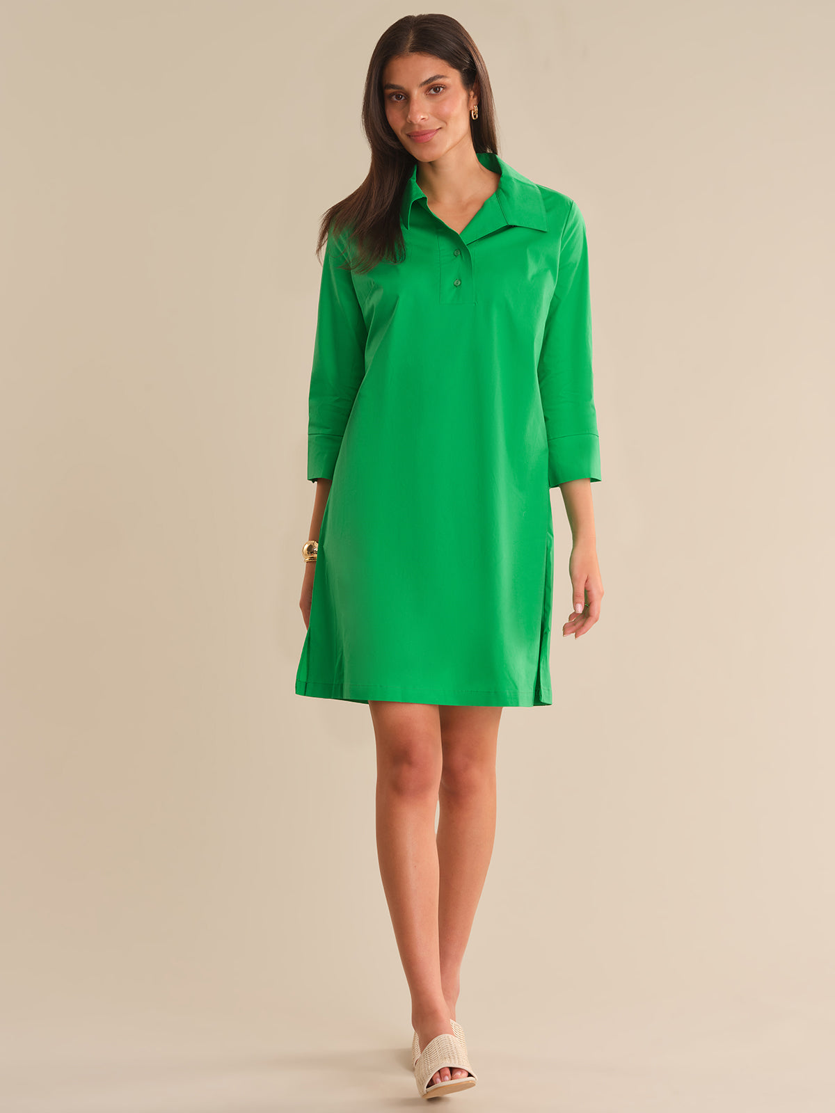 Woman wearing a green dress against a beige background