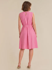 Woman wearing a pink dress on a beige background