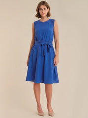 Woman wearing a blue dress against a beige background