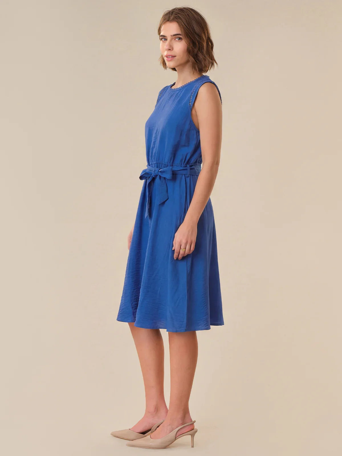 Woman wearing a blue dress on a beige background