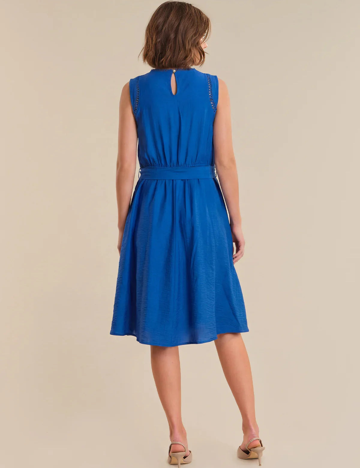 Woman wearing a blue dress on a beige background