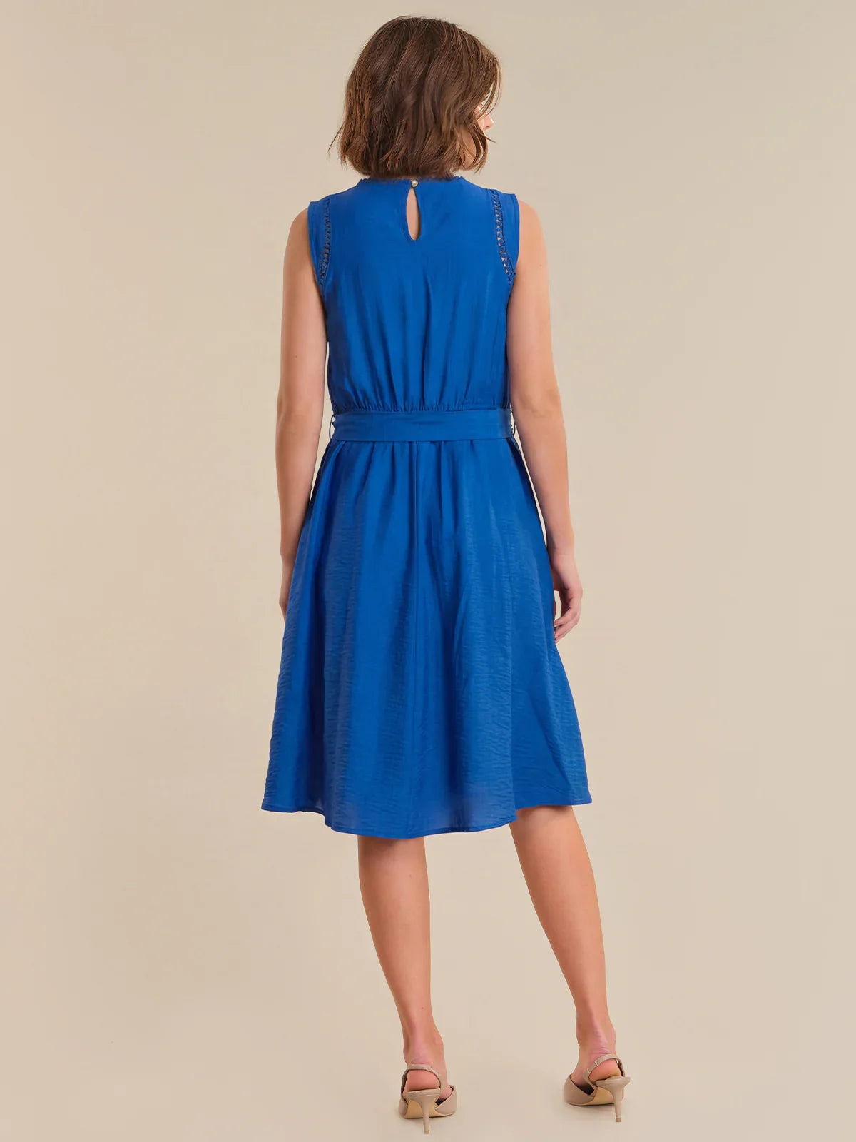 Woman wearing a blue dress on a beige background