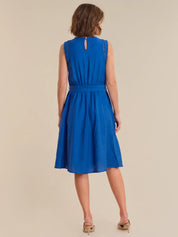 Woman wearing a blue dress on a beige background