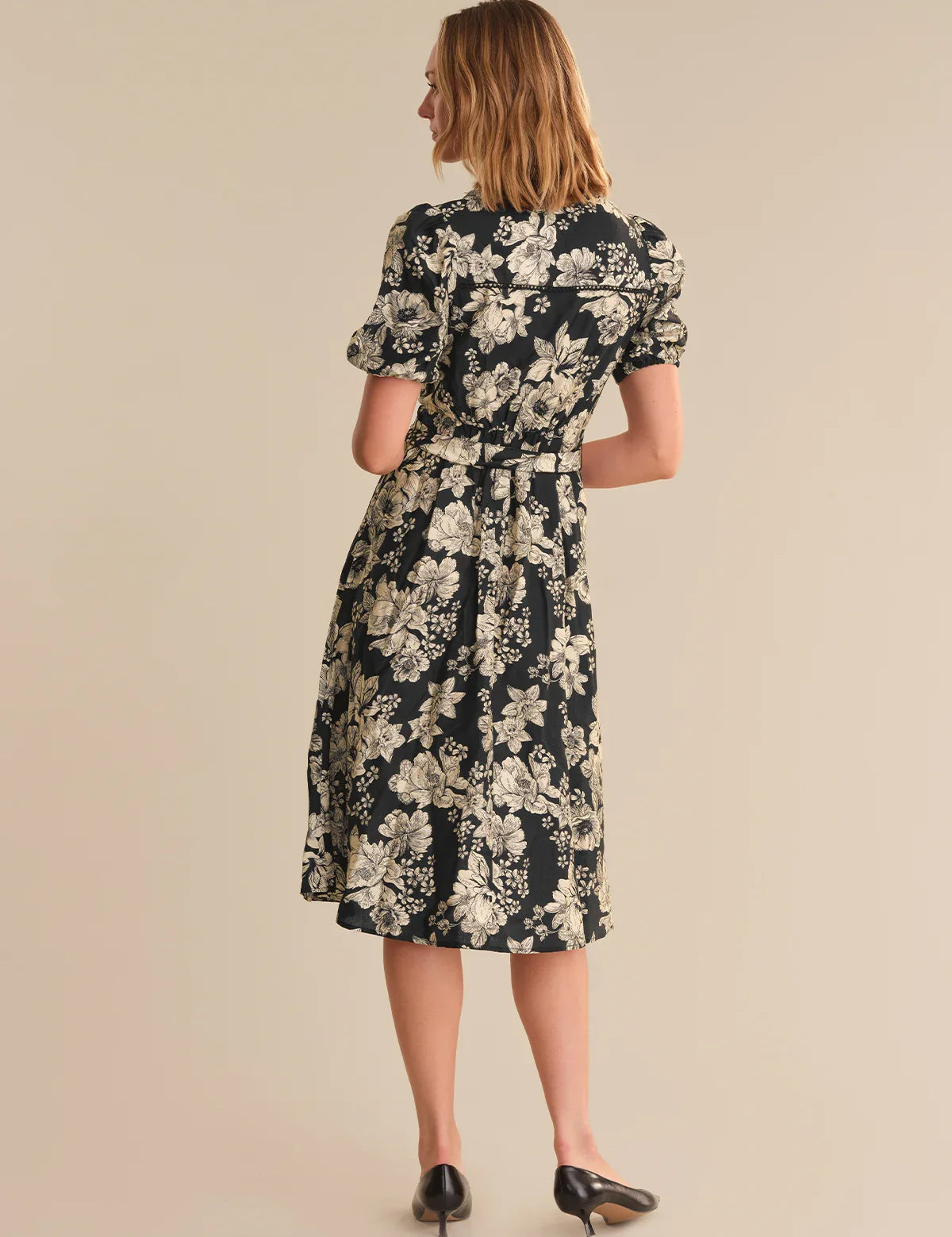 Woman wearing a floral dress on a beige background