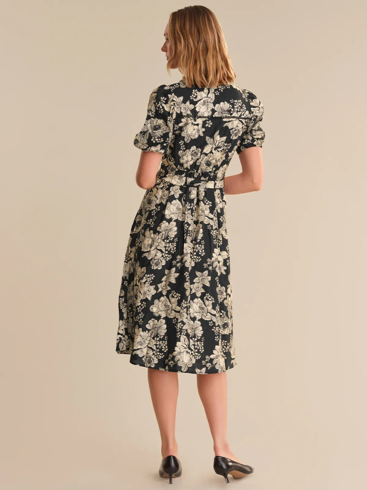Woman wearing a floral dress on a beige background