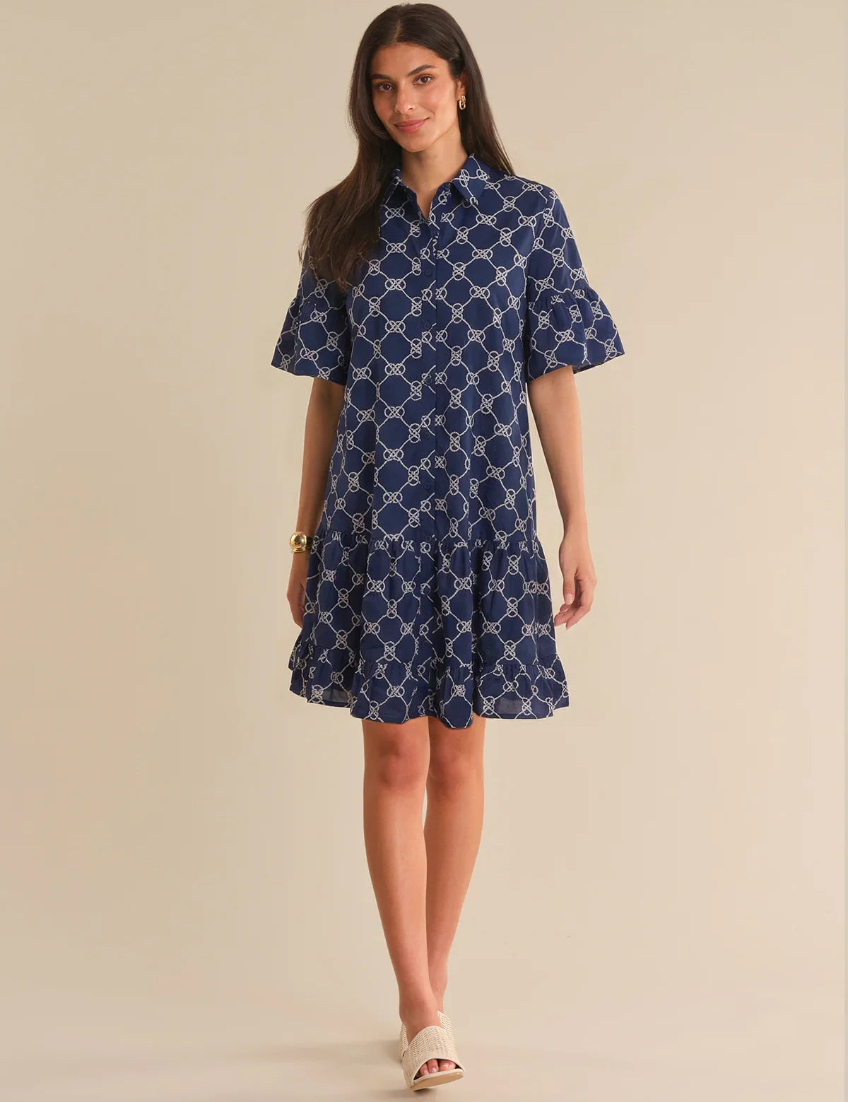 Woman wearing a blue patterned dress on a beige background