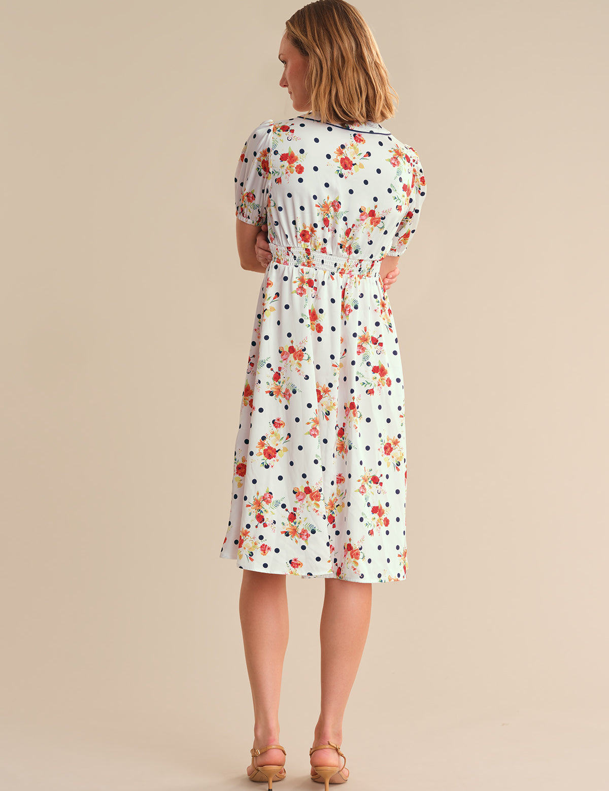 Woman wearing a floral dress on a beige background