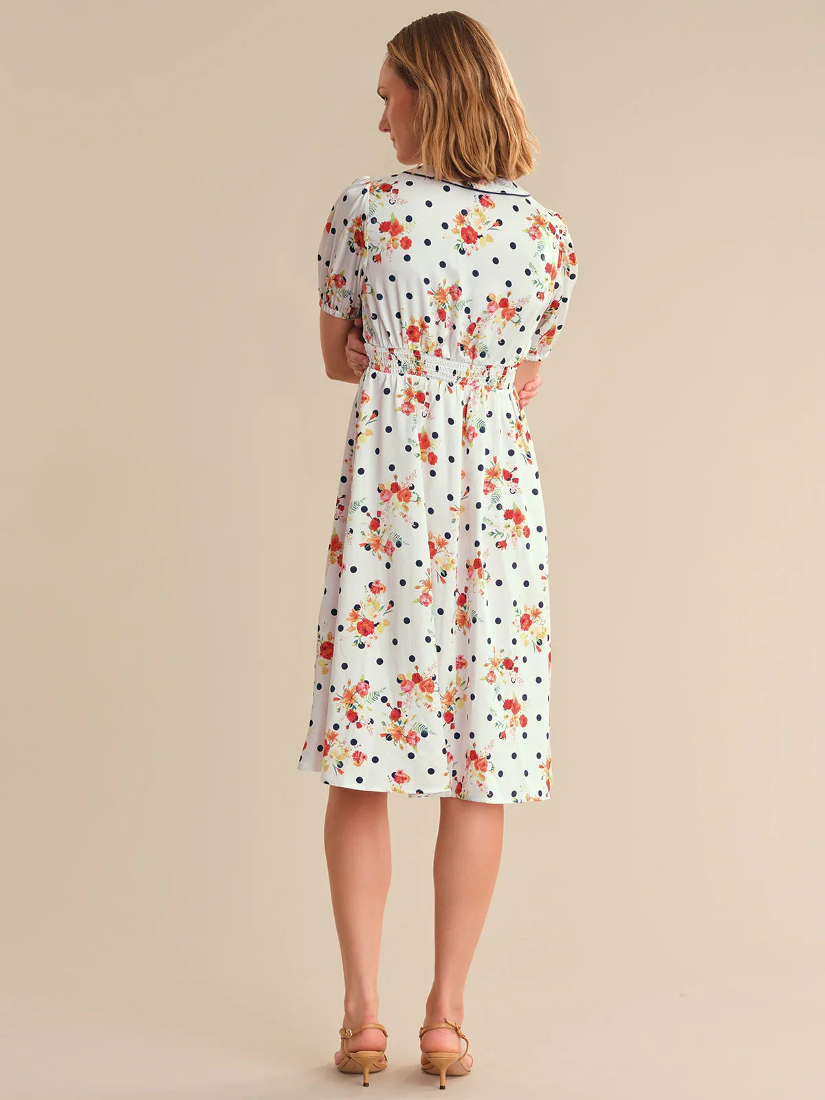 Woman wearing a floral dress on a beige background
