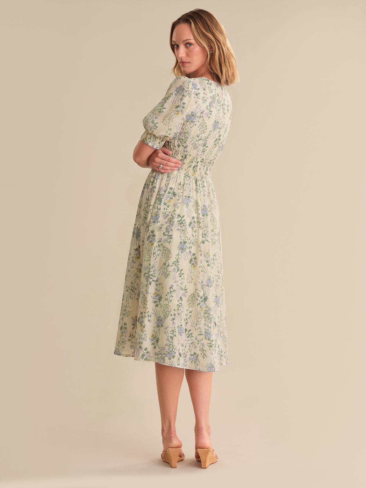 Woman wearing a floral dress against a beige background