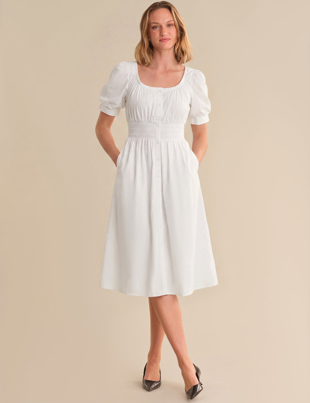 Woman wearing a white dress with short sleeves on a beige background
