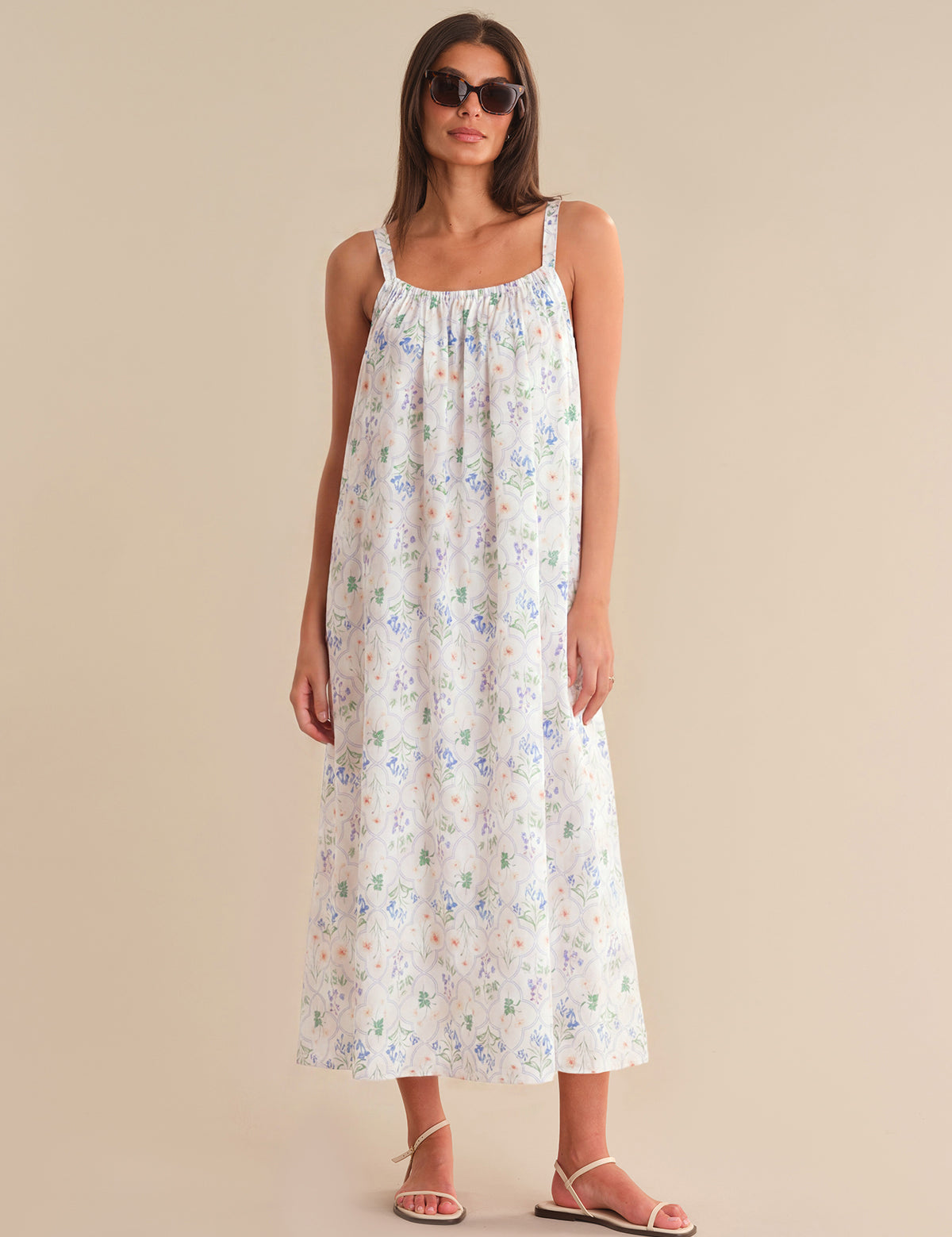 Woman wearing a floral dress against a beige background