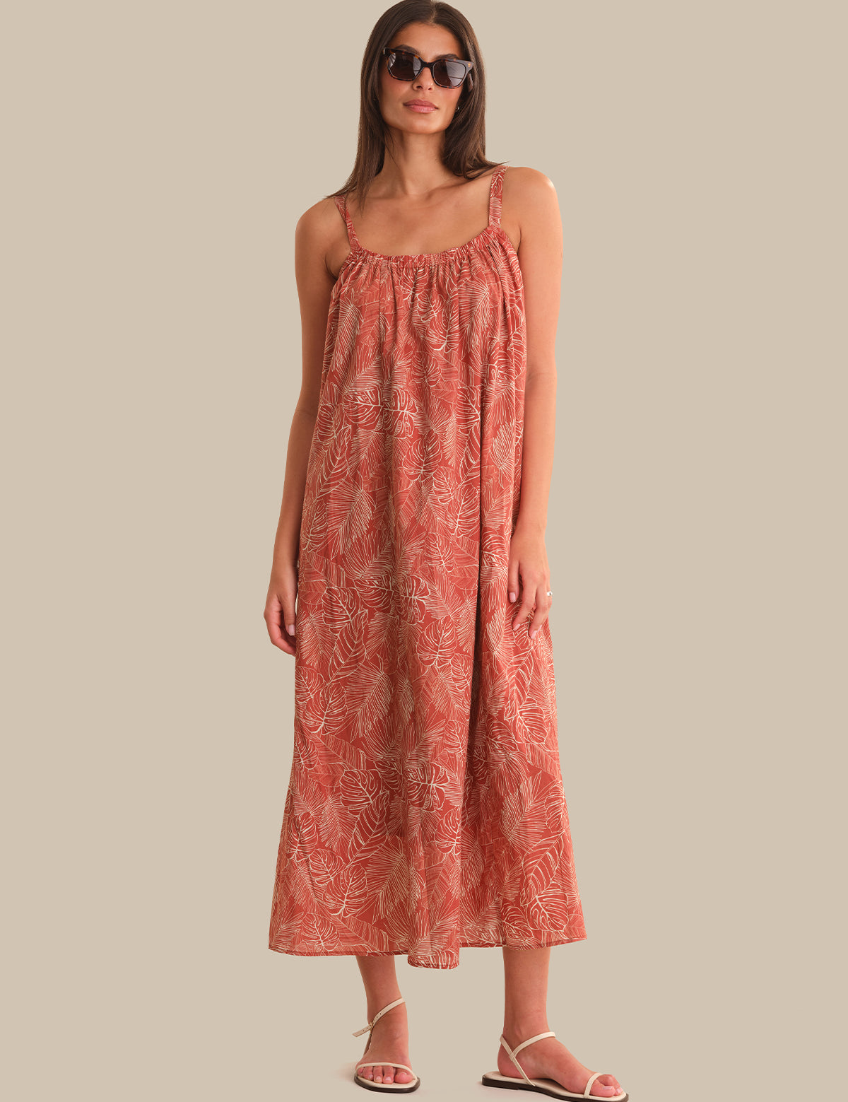 Woman wearing a red patterned dress against a beige background