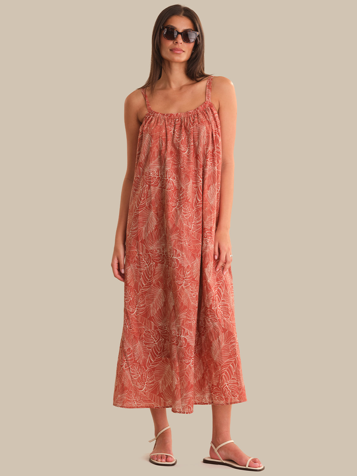 Woman wearing a red patterned dress against a beige background