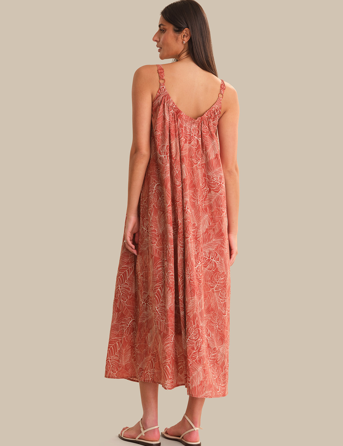 Woman wearing a patterned dress on a plain background