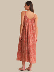 Woman wearing a patterned dress on a plain background