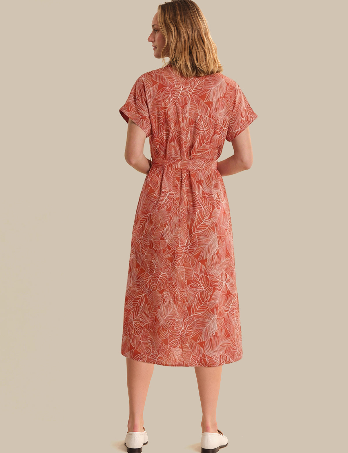 Woman wearing a red patterned dress on a beige background