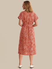 Woman wearing a red patterned dress on a beige background