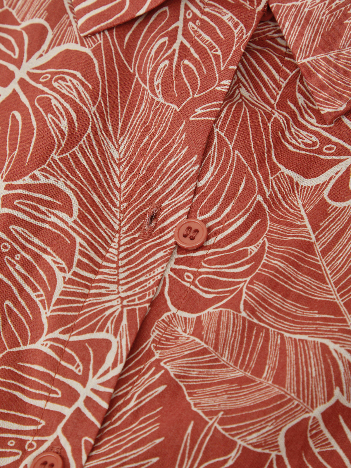 Close-up of a red shirt with white leaf pattern