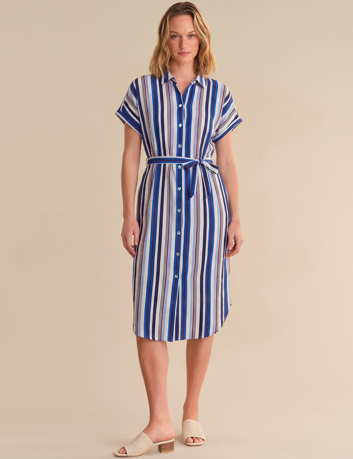 Woman wearing a blue and white striped dress on a beige background