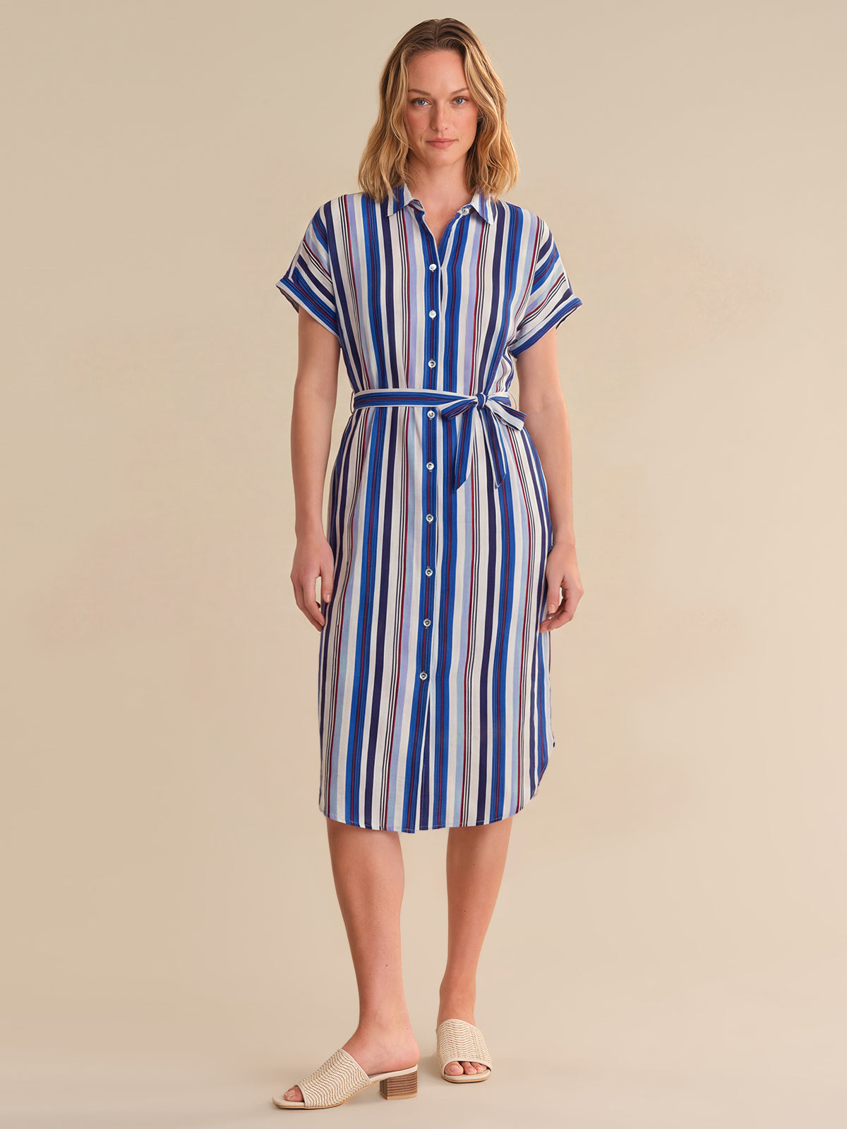 Woman wearing a blue and white striped dress on a beige background