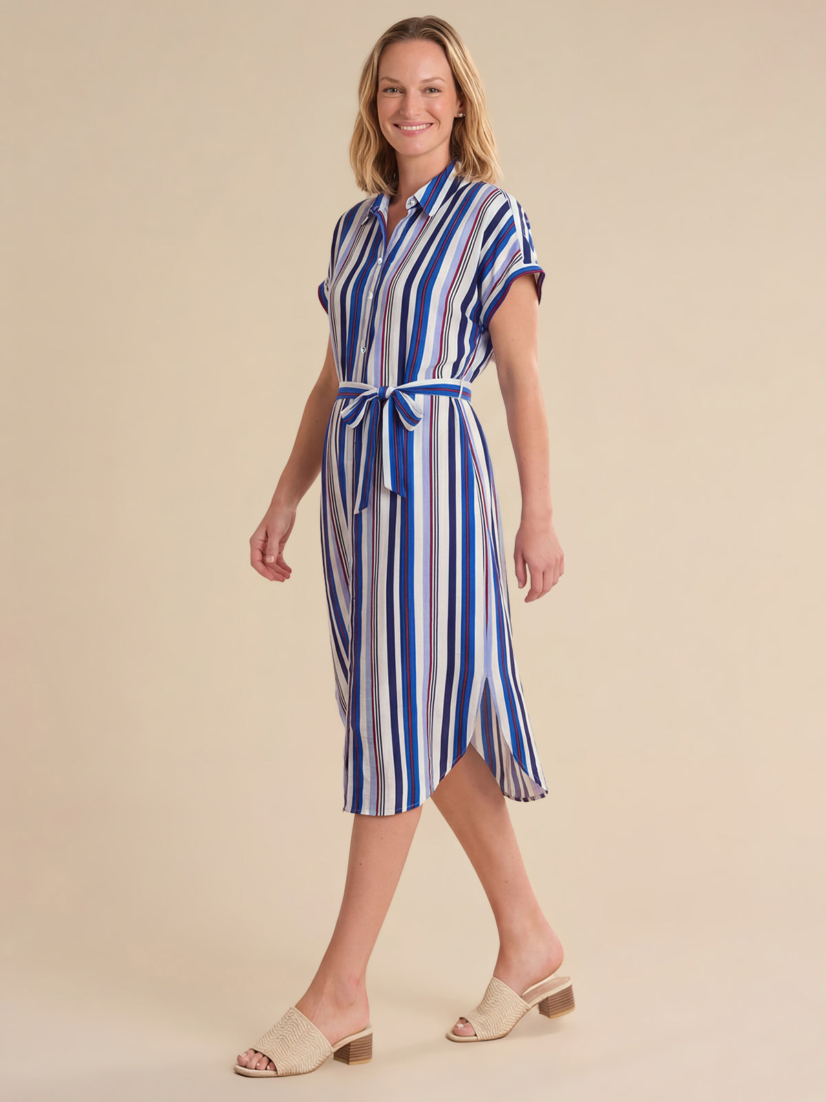 Woman wearing a blue and white striped dress on a beige background