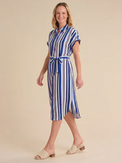 Woman wearing a blue and white striped dress on a beige background