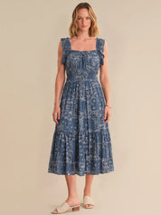 Woman wearing a blue patterned dress against a beige background