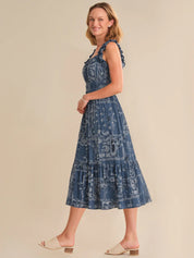 Woman wearing a blue patterned dress on a beige background
