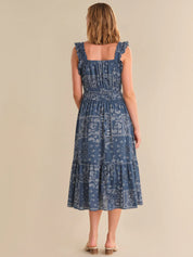 Woman wearing a blue patterned dress on a beige background