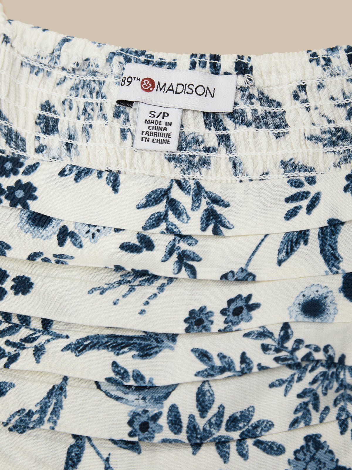 White fabric with blue floral pattern and 'Madison' label.