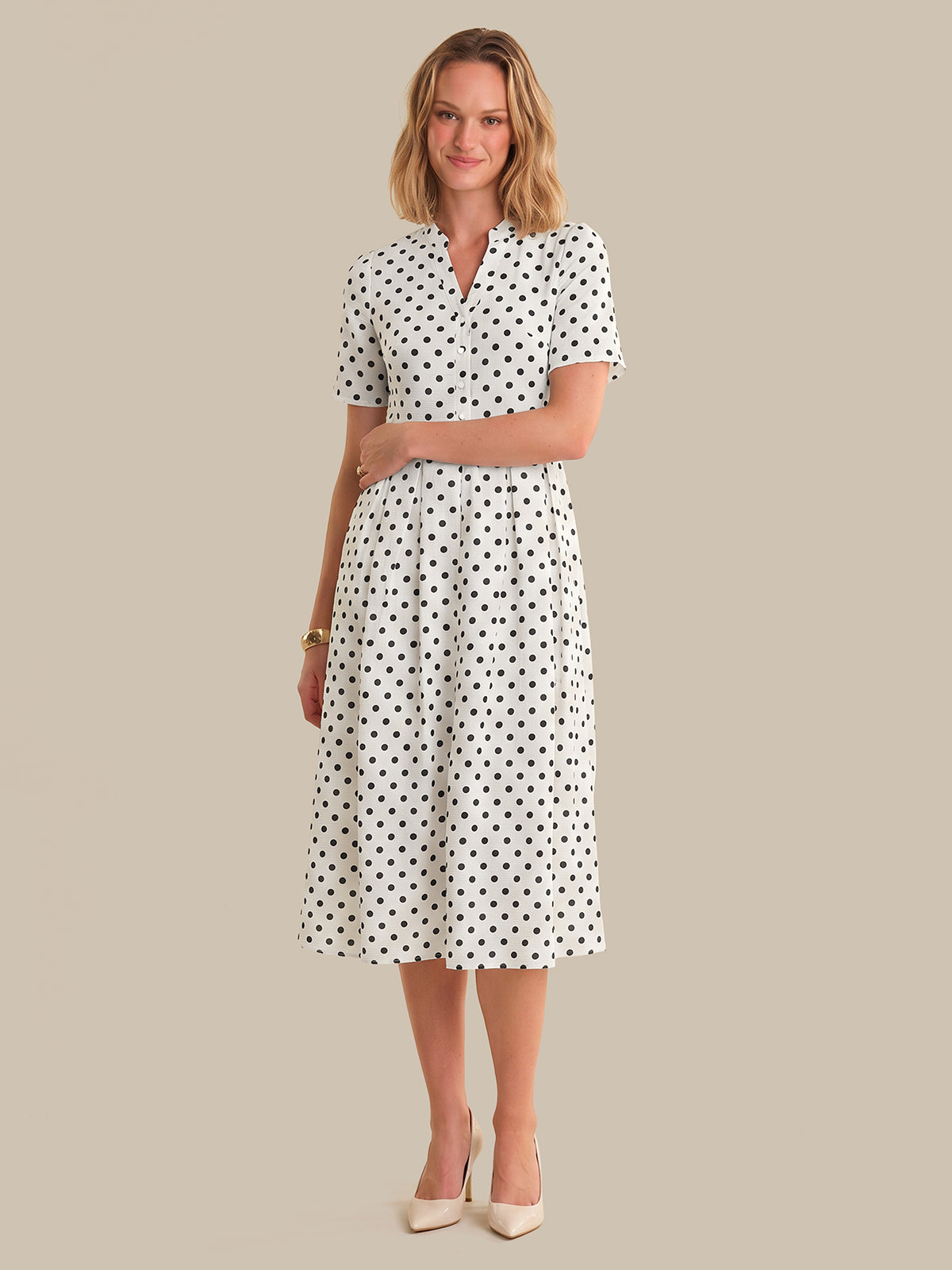 Woman wearing a polka dot dress on a beige background