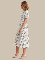 Woman wearing a polka dot dress on a beige background