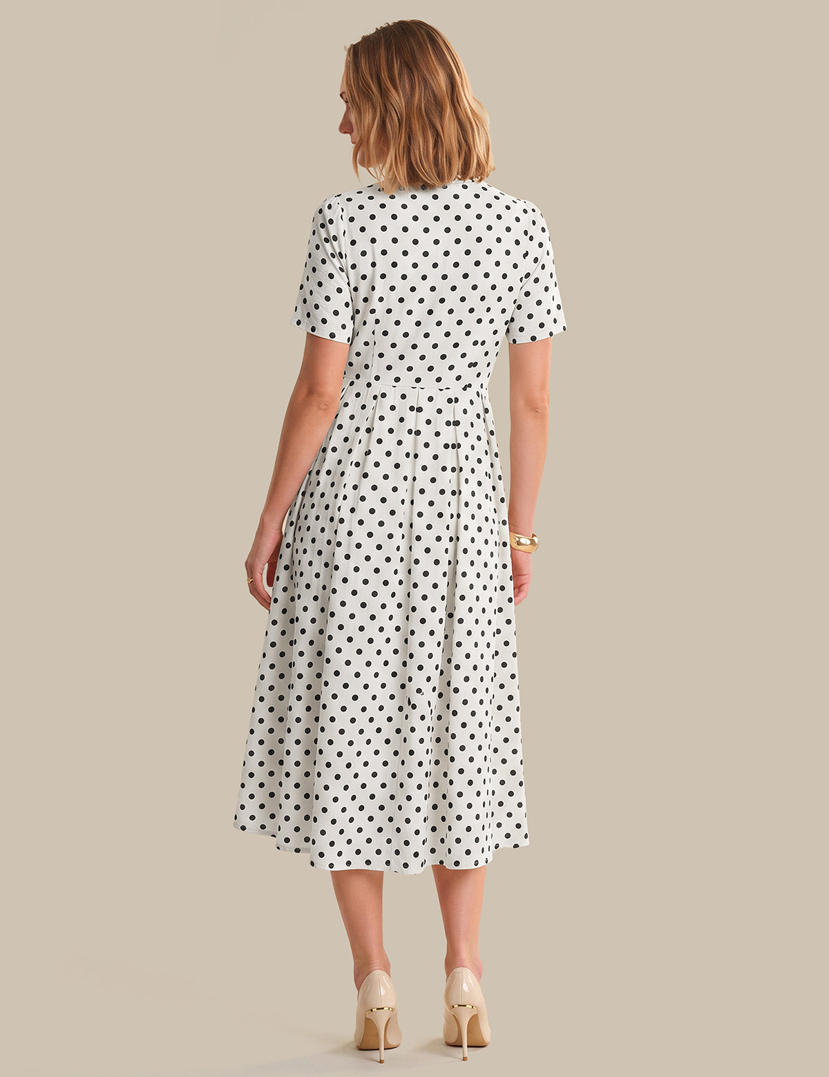 Woman wearing a polka dot dress on a beige background