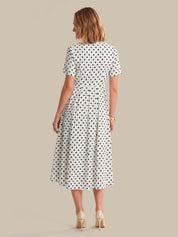 Woman wearing a polka dot dress on a beige background