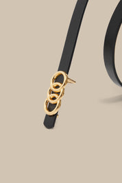 Black belt with a gold buckle on a beige background