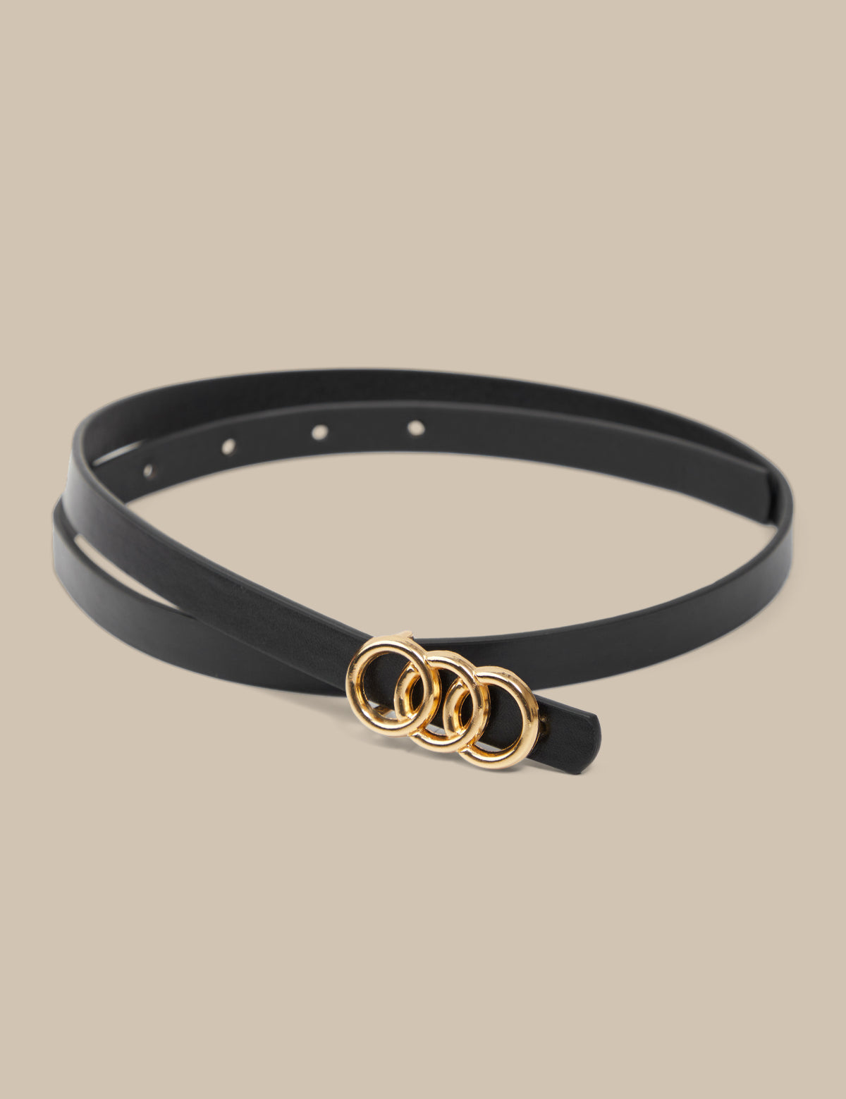 Black belt with gold rings on a beige background