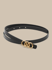 Black belt with gold rings on a beige background