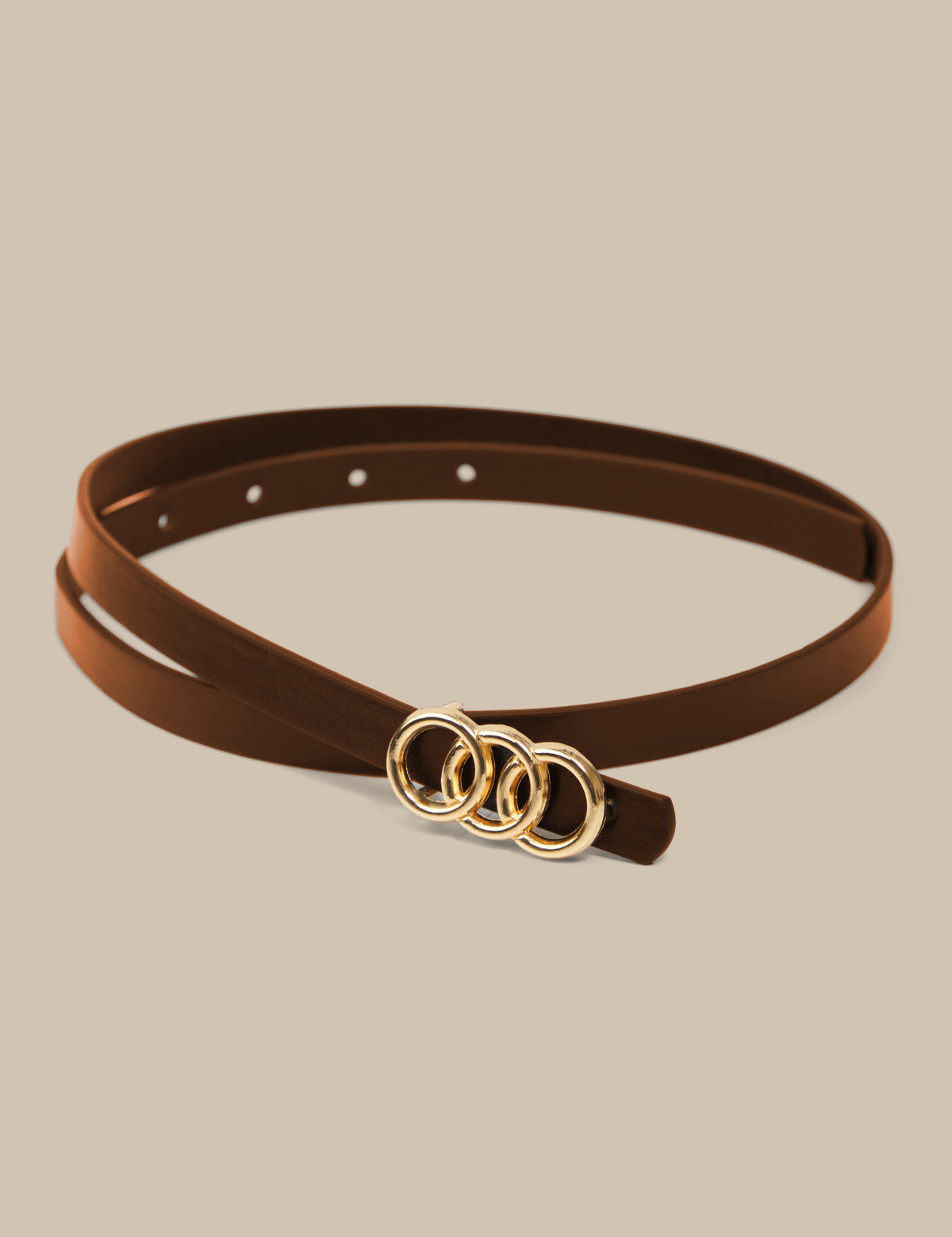 Brown belt with gold rings on a beige background